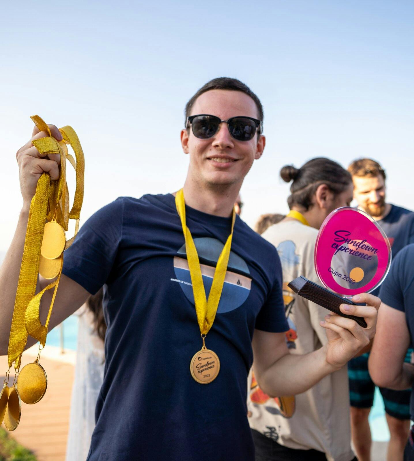 Person holding medals from a party